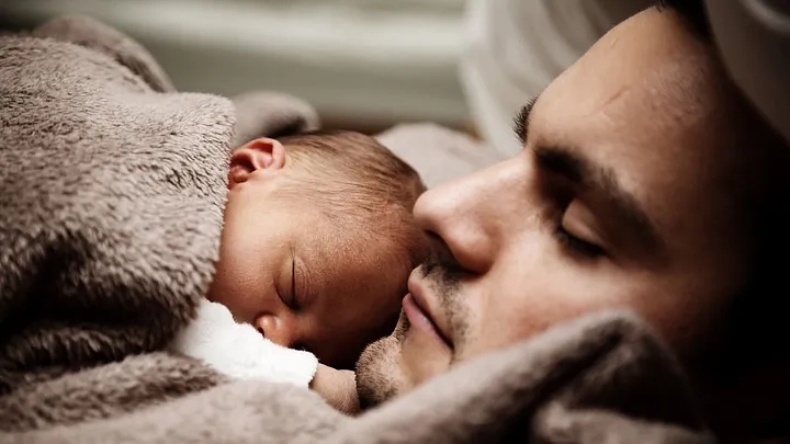 parent snuggling with baby