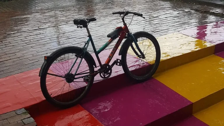 bicycle parked on a colorfully painted staircase on the sidewalk in the rain
