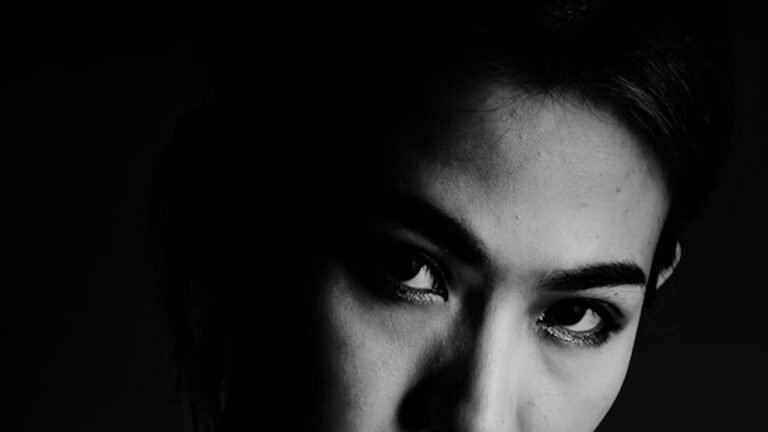 person in the darkness, looking up and to the side
