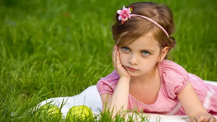 bored princess girl in pink headband resting chin in hand