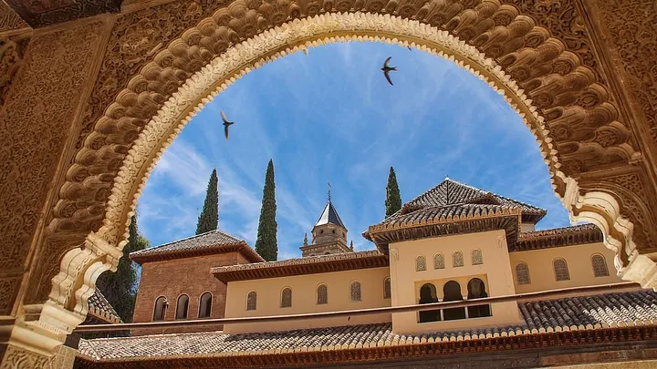 old-style building seen through a large ornate archway