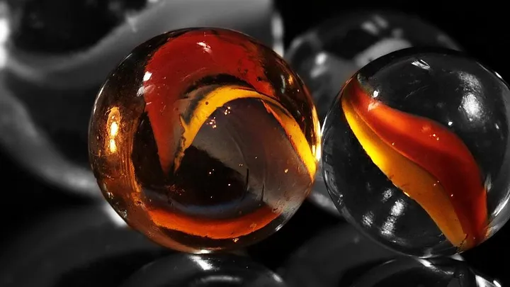 glass cat's eye marbles with red swirls inside