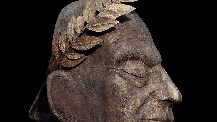 modern sculpture of head with a wreath