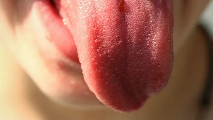 person sticks out tongue (close-up)