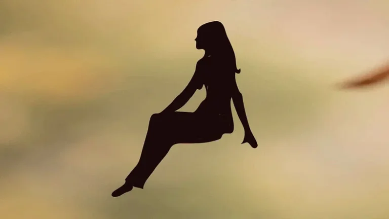 silhouette of seated woman floating on a yellowish background