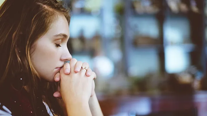 person with hands clasped as if in prayer