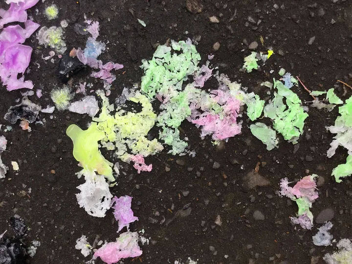 abstract pattern of colored melted wax that was spilled in a puddle. the puddle has dried, leaving the wax in a spatter pattern.