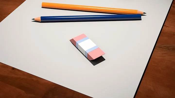 two pencils and an eraser in the trans-flag colors (pink, blue, white)