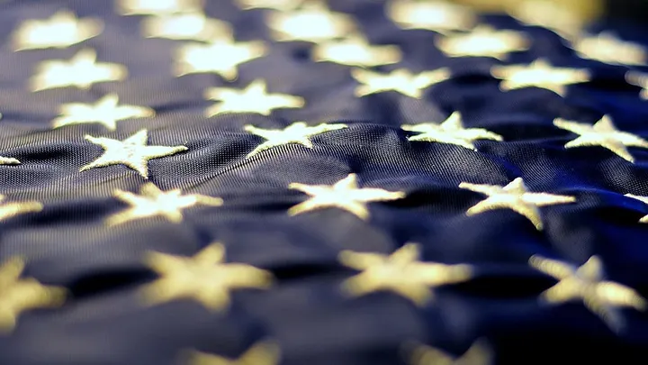 textured closeup of US flag: white stars on blue background