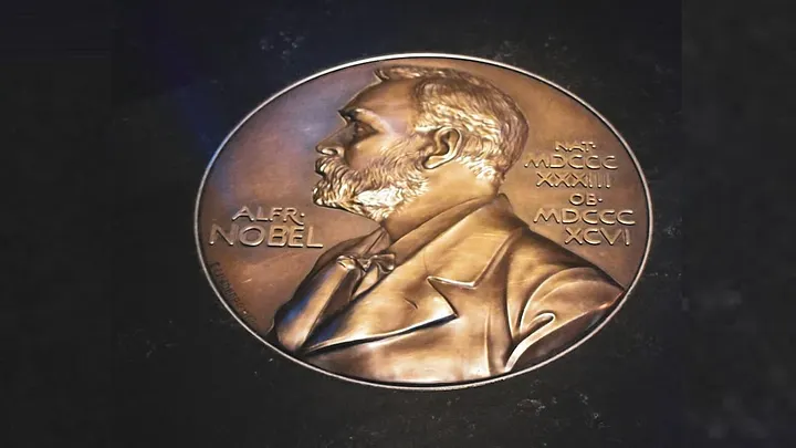 closeup of a coin that says Alfr. Nobel embossed with his image